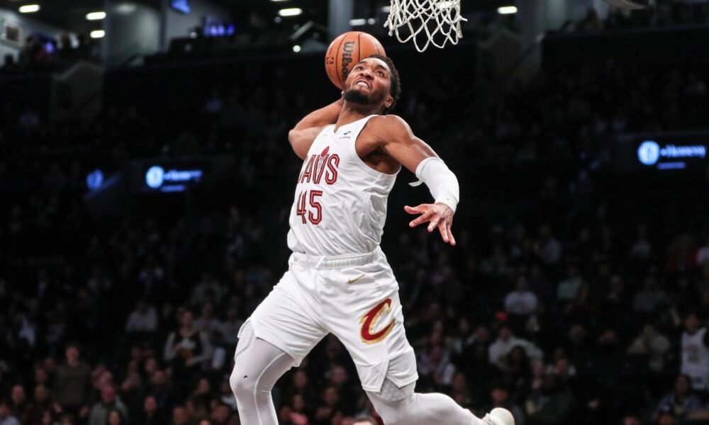 Donovan Mitchell driving past defenders—“Spida’s” scoring prowess parallels his $20 M net worth and growing legacy in Cleveland.