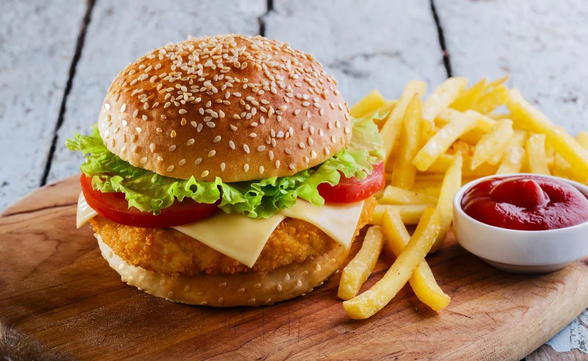 A table filled with classic American favorites: burgers, pizza, fried chicken, tacos, and donuts — a true taste of the USA in every bite.