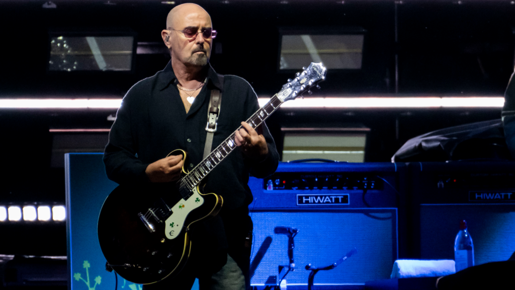 Paul “Bonehead” Arthurs, founding guitarist of Oasis, announced a temporary break from the band’s reunion tour to continue prostate cancer treatment, promising fans he’ll return “stronger than ever.”