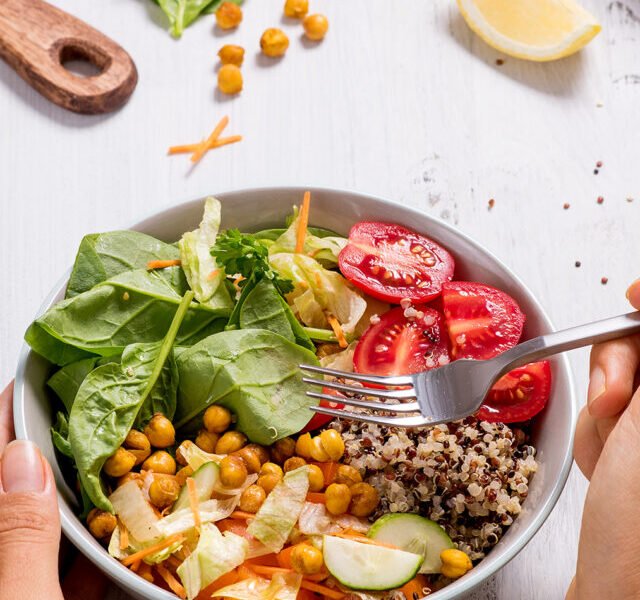 closeup_hand_with_quinoa_salad_1199279481