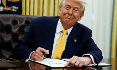 Former U.S. President Donald Trump signs pardon documents as part of a recent wave of clemency actions