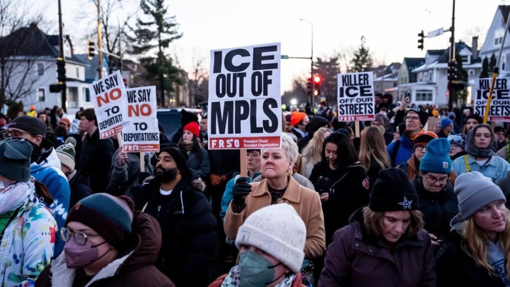 Masked federal officers approach a vehicle in Minneapolis moments before a fatal ICE shooting that has triggered nationwide political backlash.